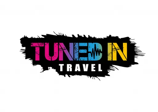 Colourful logo featuring the text TUNED IN TRAVEL with a paint splash effect.