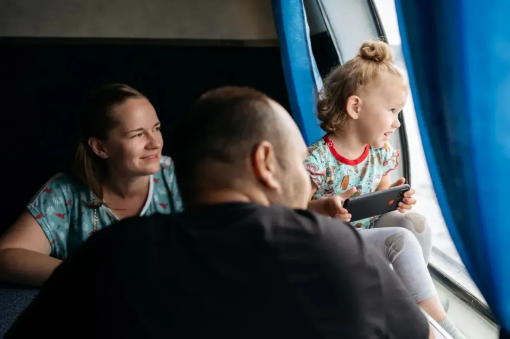 child-engrossed-in-mobile-game-with-parents-on-fer-2025
