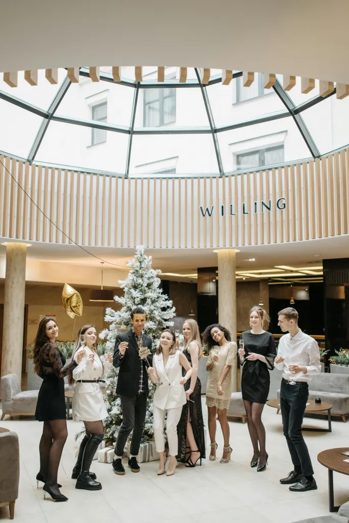 a work team posing for a photo in front of a christmas tree