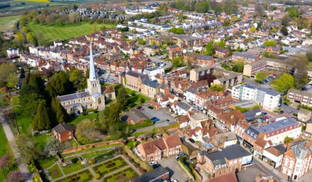 Aerial view of a town featuring a church, residential buildings, and green spaces.