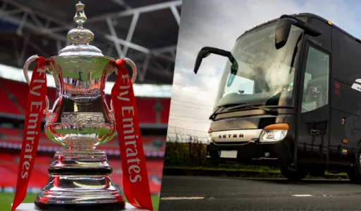 Trophy with red ribbons is shown alongside a black coach bus parked on a road.