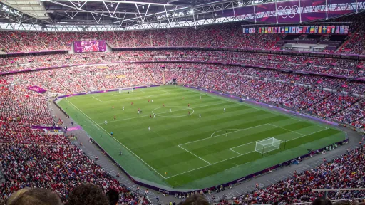 A large stadium filled with spectators watching a football match on the pitch below.