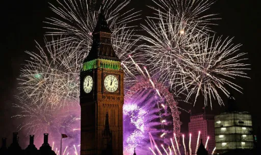 Fireworks illuminate the night sky above the Big Ben clock tower in London, creating a vibrant display of colours.